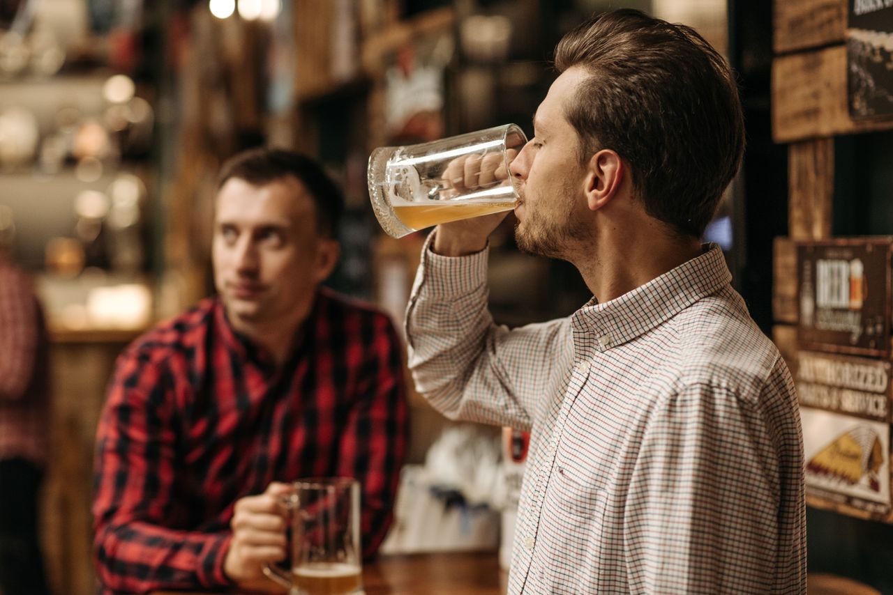 services-02 Two men enjoy refreshing draft beer in a cozy pub atmosphere.