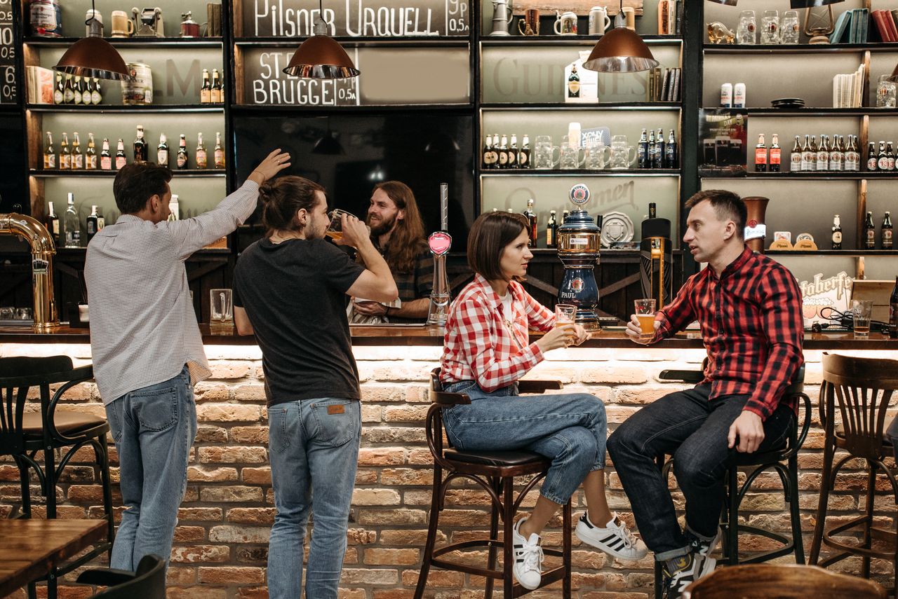 about-img A group of friends socializing and enjoying drinks at a lively bar.